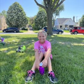 Camp GOTR participant smiles at the camera while on a water break.
